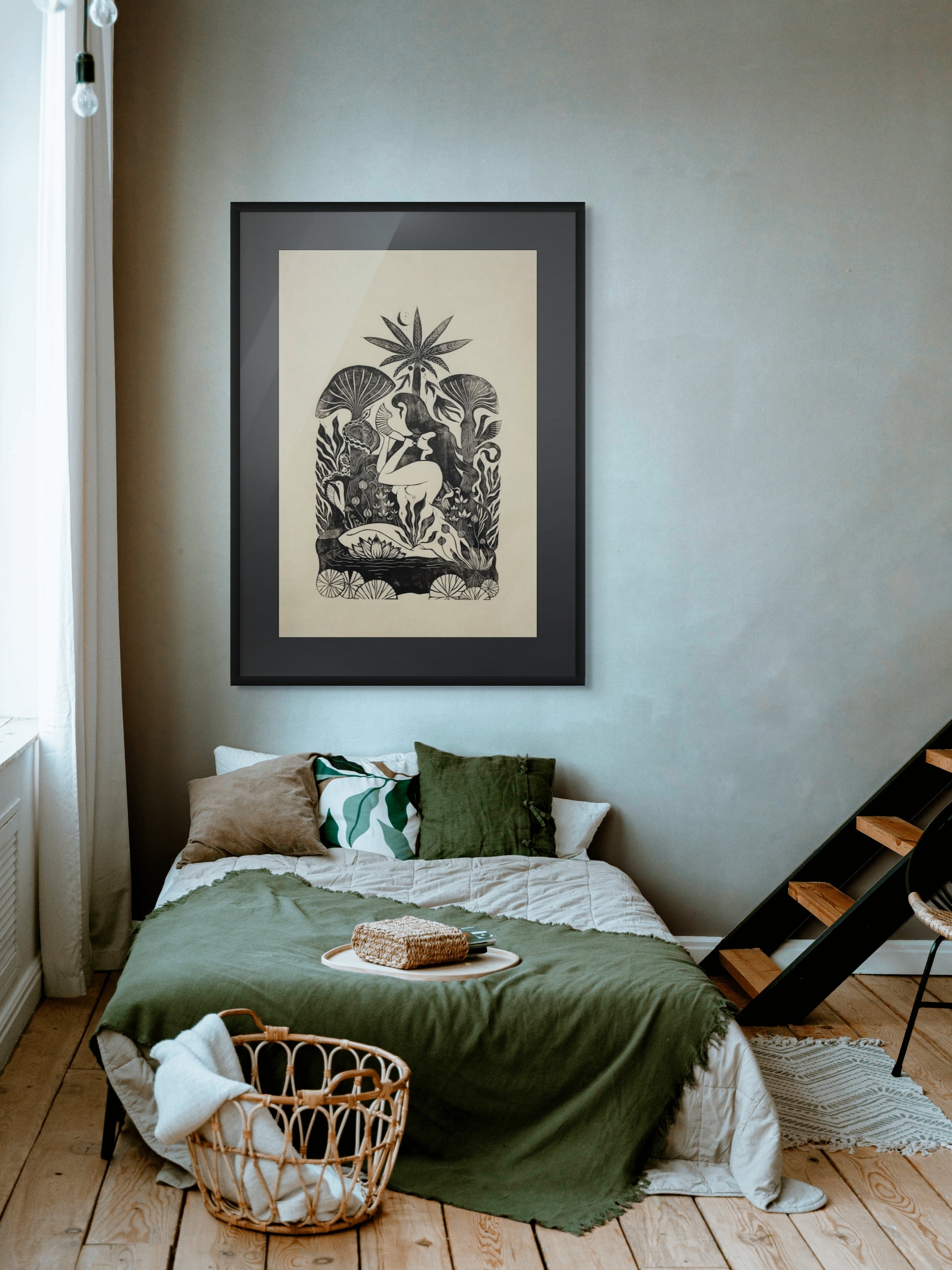 Bedroom with a bed, green blanket, and framed artwork on the wall.
