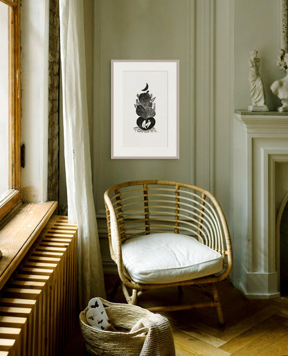 Rattan chair with white cushion in a room with framed artwork on the wall.