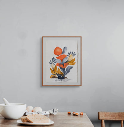 Framed floral artwork on a gray wall above a wooden table with a bowl and bread.